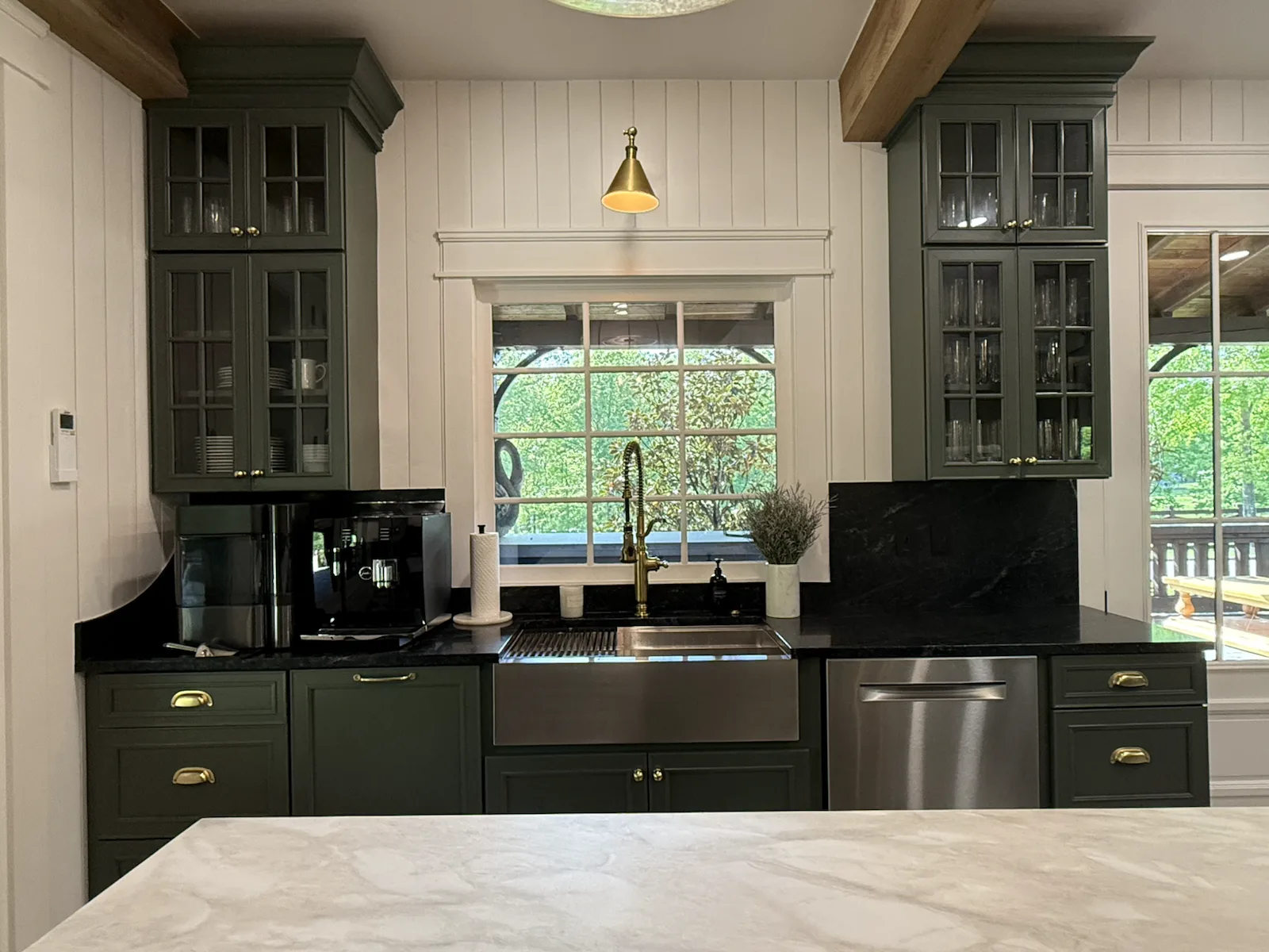 Cortina stainless farmhouse sink with brass faucet and soapstone counters