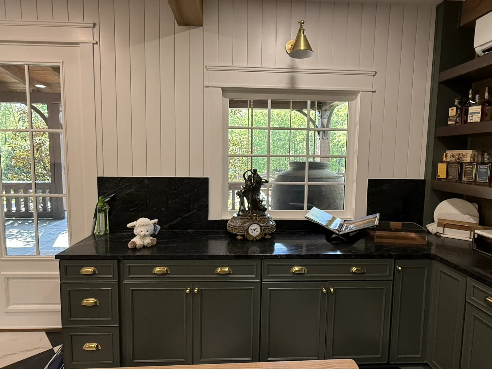 Cortina soapstone counter and window with an antique clock and brass sconce