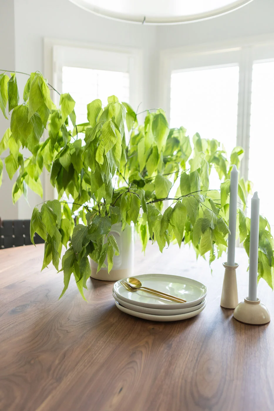 Gweneth dining table detail with greenery and brass flatware