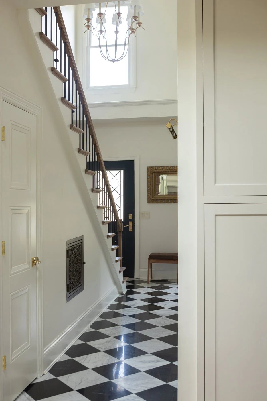 Riverview foyer with checkerboard marble floor and staircase