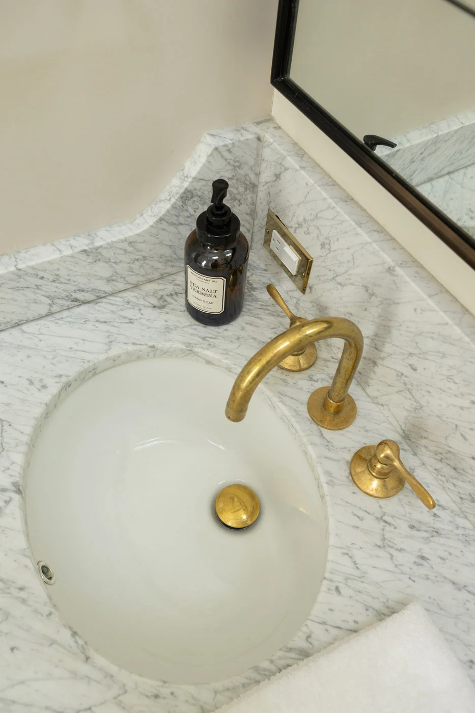 Riverview bathroom vanity with marble countertop and brass fixtures
